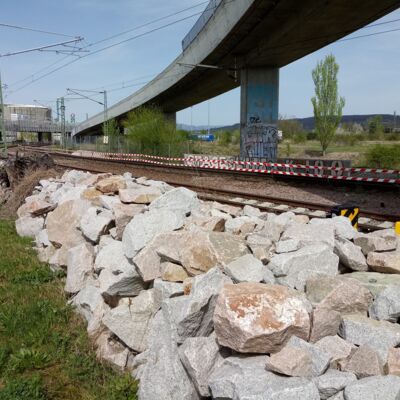 Steinhaufen liegen entlang eines alten Gleises.