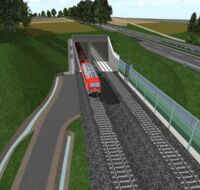 Ein Zug fährt in einen Tunnel, auf dem ein Feld liegt.