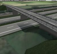 Eine Autobrücke führt über Gleise und eine Autobahn.