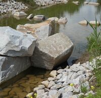 Fluss mit flachen Reihen aus Stein.