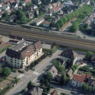 Gleise mit Schallschutzwänden führt durch eine Stadt.