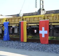Die Flaggen der EU, Deutschlands und der Schweiz hängen nebeneinander.