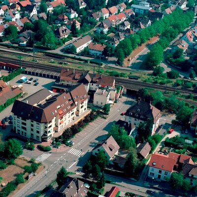 Gleise ohne Schallschutzwände führen durch eine Stadt.
