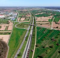 Ein Autobahnkreuz führt über einen Eingang eines Eisenbahntunnels