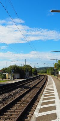 Ein zweigleisiger Haltepunkt mit Sitzgelegenheiten.