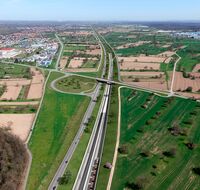 Ein Autobahnkreuz führt über einen Eingang eines Eisenbahntunnels