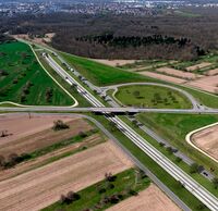 Ein Autobahnkreuz führt über einen Eingang eines Eisenbahntunnels.