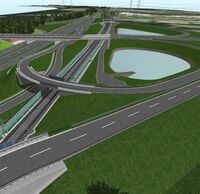Eine Bahnstrecke führt unter einem Autobahnkreuz hindurch.