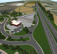 Eine große Raststätte neben einer Autobahn und Feldern in der Umgebung.