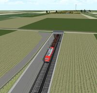 Ein Zug unterquert eine Feldlandschaft.