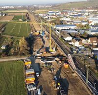 Zwei Kräne stehen an einer Baustelle für einen Haltepunkt.