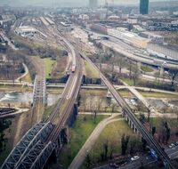 Viele Gleise und eine Autobahnbrücke führen über einen Fluss zu einem Bahnhof.