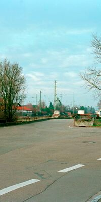 Eine Straße führt an Schienen ohne Schallschutz entlang.