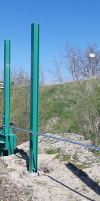 Senkrechte Pfosten aus Metall entlang der Schiene.