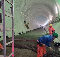 Arbeiter schichten Beton im Tunnel auf.