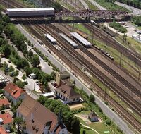 Ein Bahnhof von oben mit Brücke im Hintergrund.