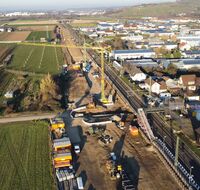 Zwei Kräne stehen an einer Baustelle für einen Haltepunkt.