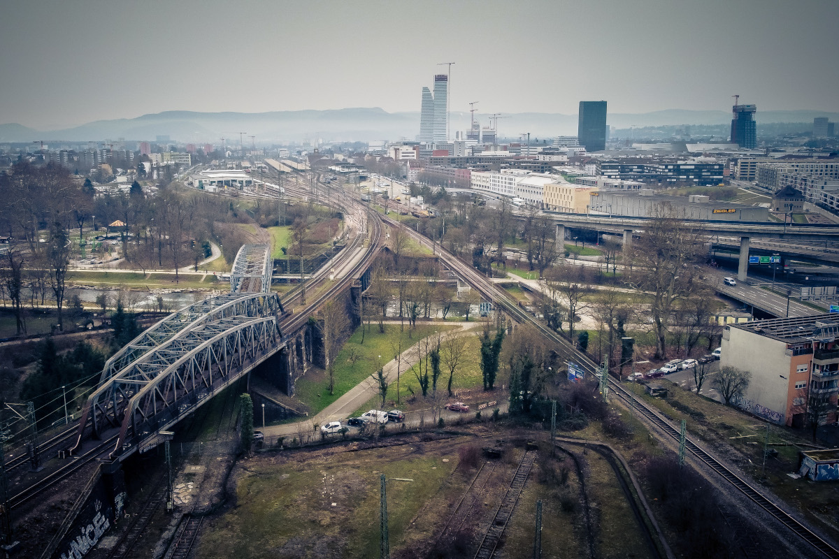 Perspektive von oben auf ein Netz aus Straßen und Schienen.