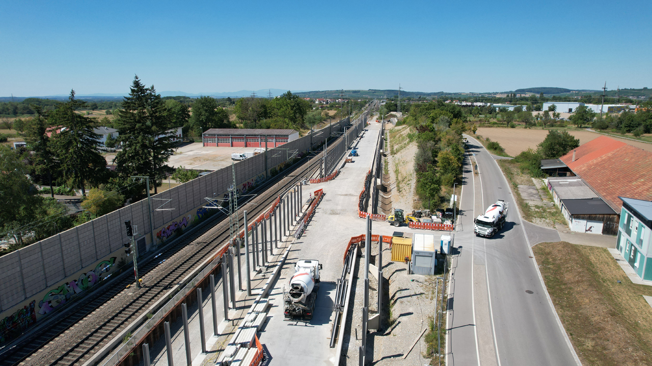 Eine Baustelle an einem Gleis. Zwei Lkws sind zu sehen.