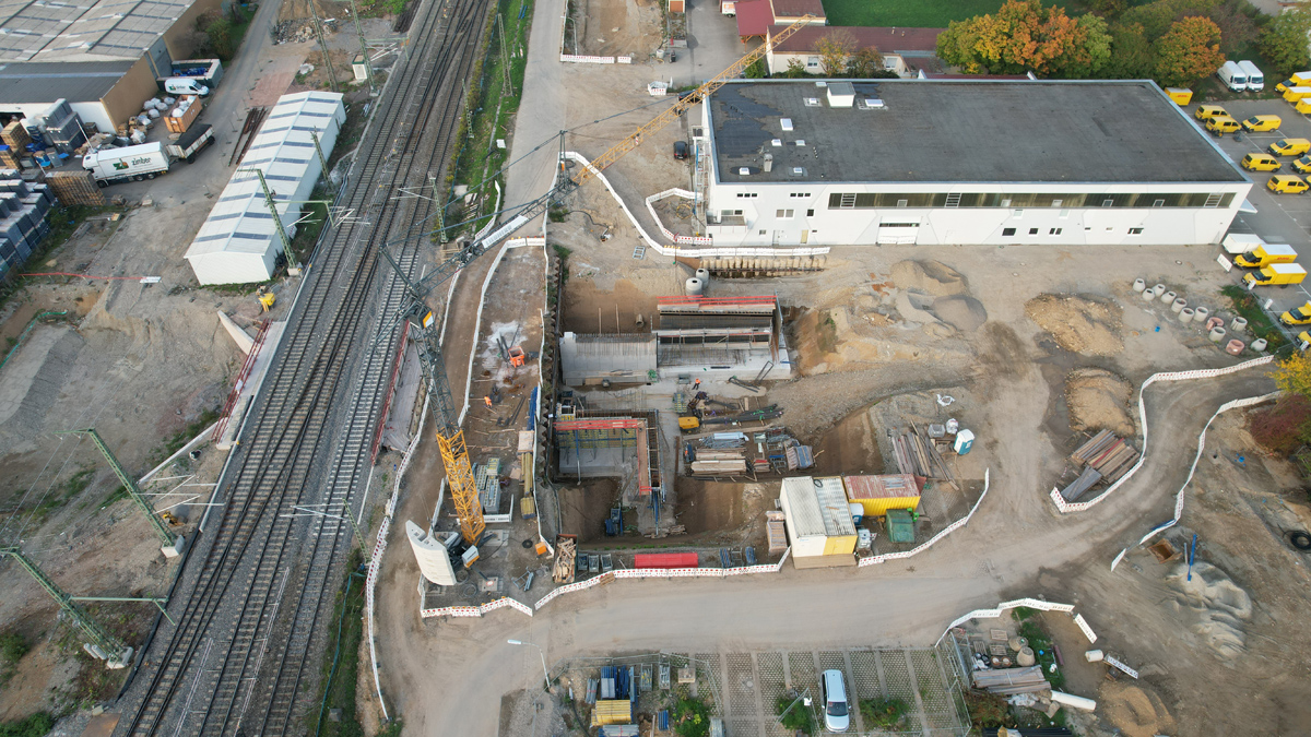 Eine Baustelle an einem Gleis. Rechts arbeitet die Bahn an den Seitenwänden des Rahmenbauwerks.