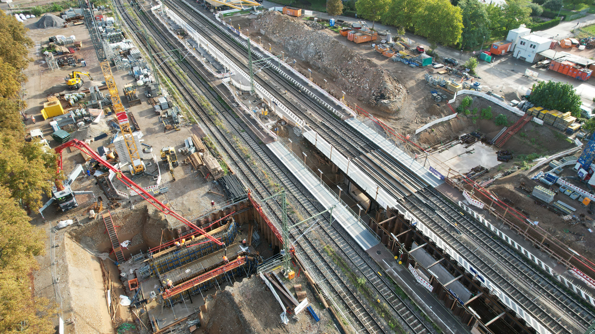 Eine Baustelle an einem Gleis. Links steht ein Kran und das Rahmenbauwerk ohne Überbau