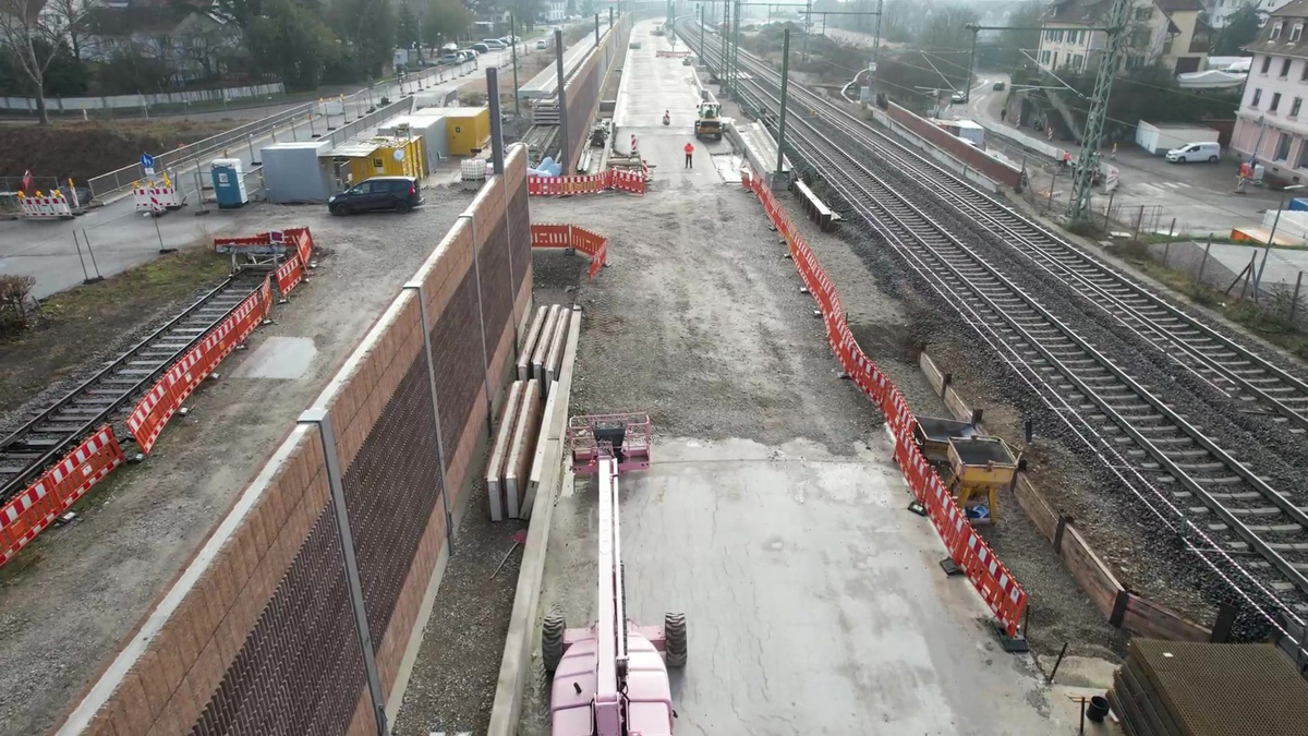 Eine Baustelle an einem Gleis. Links ist eine Schallschutzwand zu sehen, die eine Lücke aufweist.