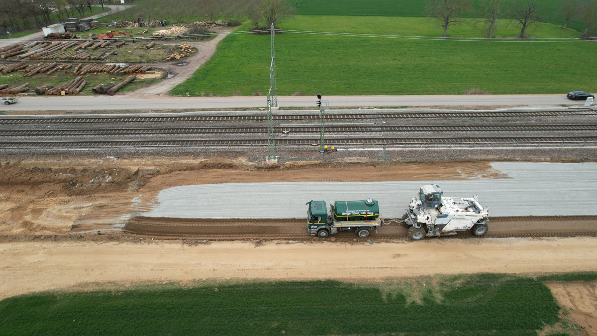 Das grüne Fahrzeug betankt die Fräse mit Wasser.