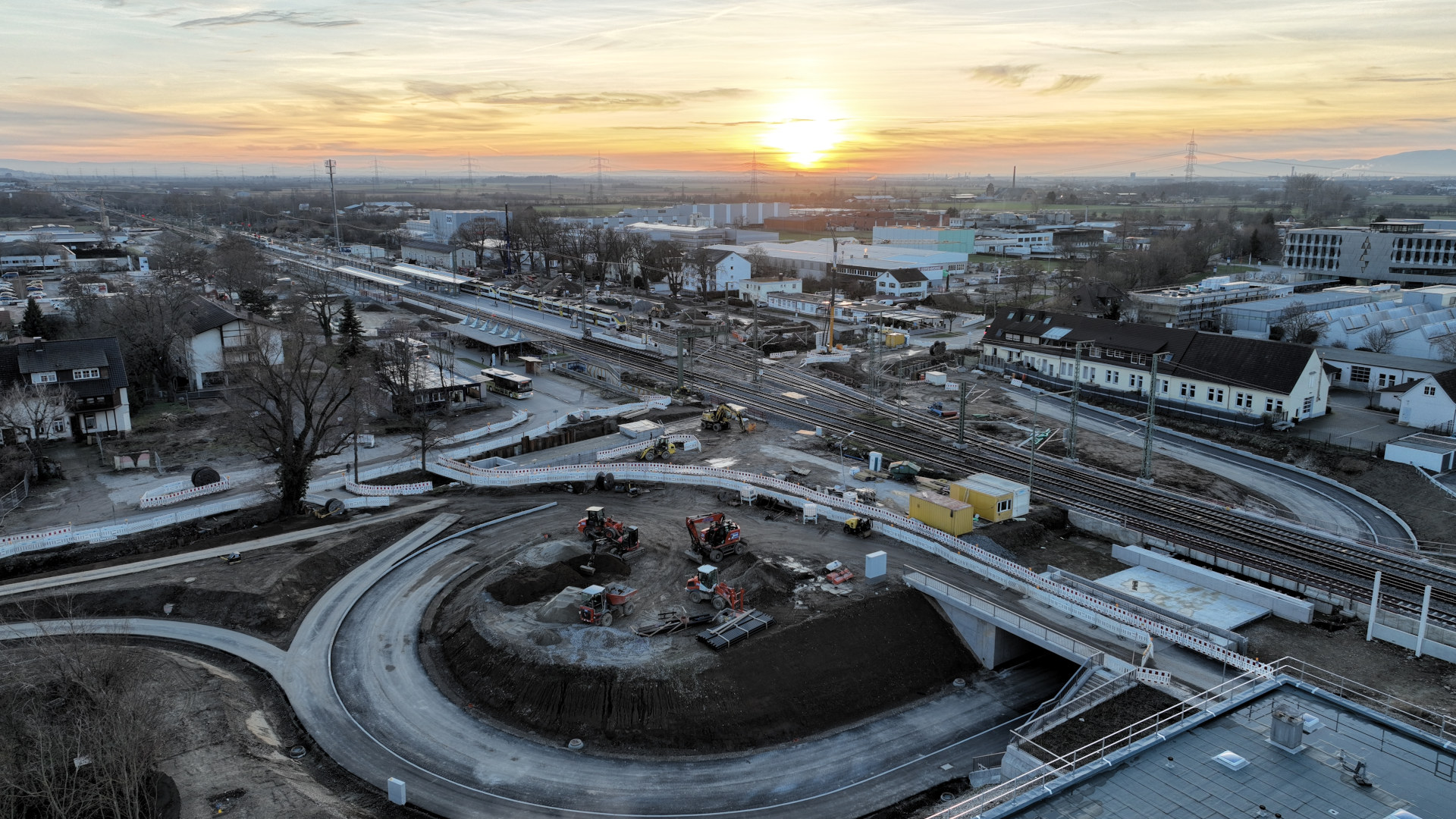 Überblick auf den Bahnhof Müllheim und den Straßenbau der Parkplatzzufahrt mit Sonnenuntergang