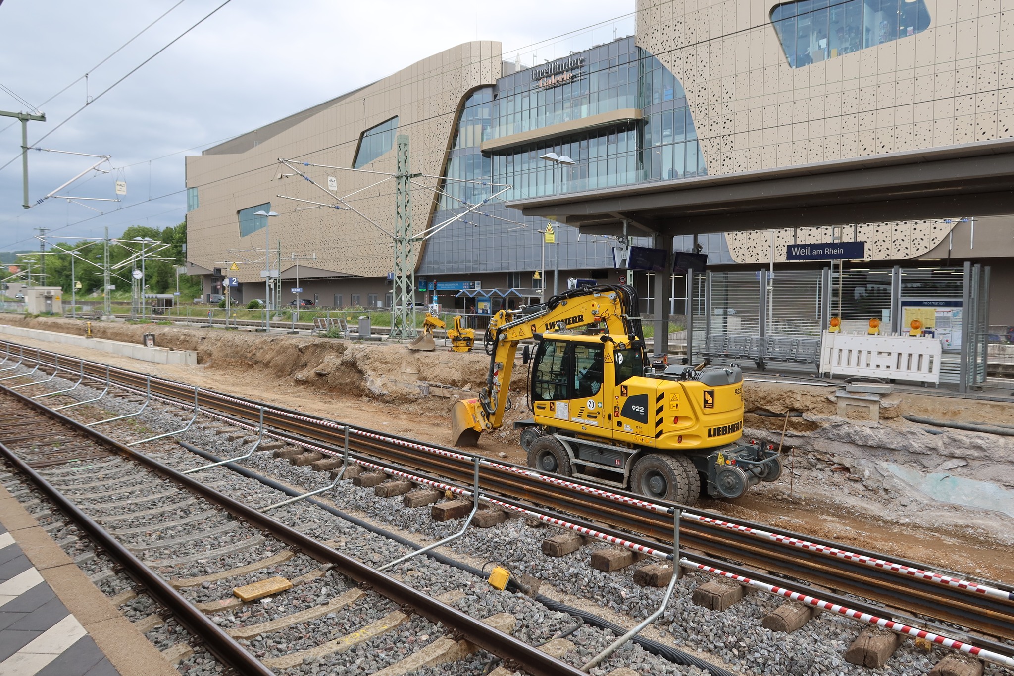 Ein Bagger gräbt den Platz für die neue Bahnsteigkante aus.