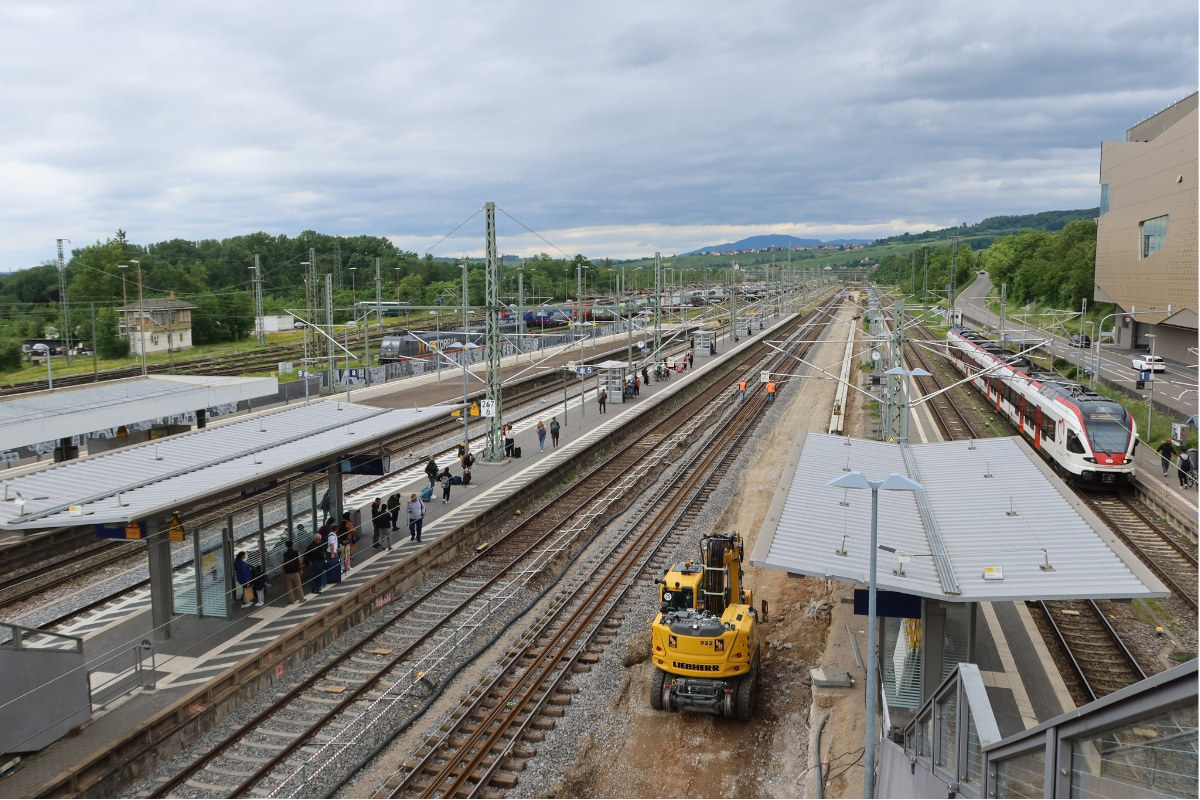 Mit einem Bagger werden Gleisarbeiten an einem Außenbahnsteig durchgeführt.
