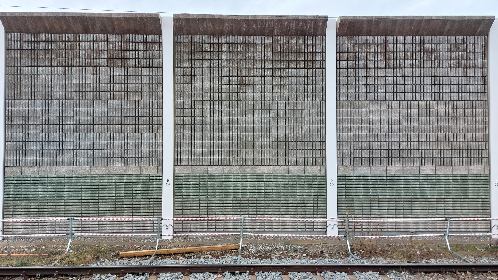 Eine Schallschutzwand mit einem grünen Streifen.